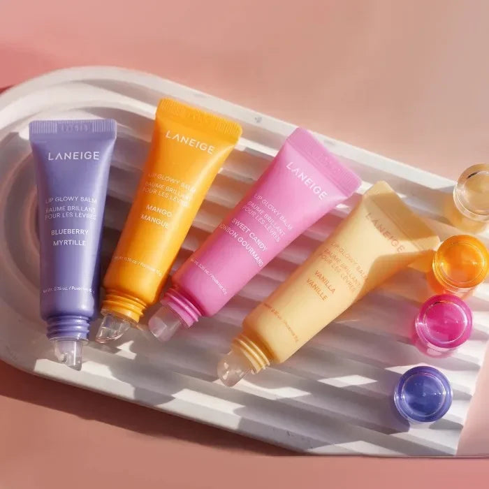 Laneige Lip Glowy Balm set in blueberry, mango, sweet candy, and vanilla, featuring hydrating, glossy tinted tubes.