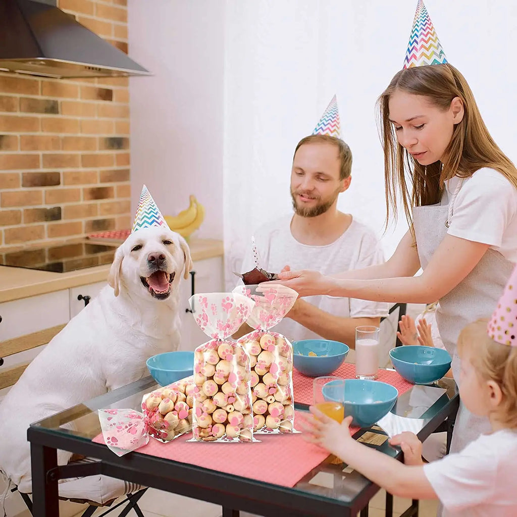 Clear cellophane bags with pink paw prints for dog birthday treats, party favors, and heat-sealable candy packaging.
