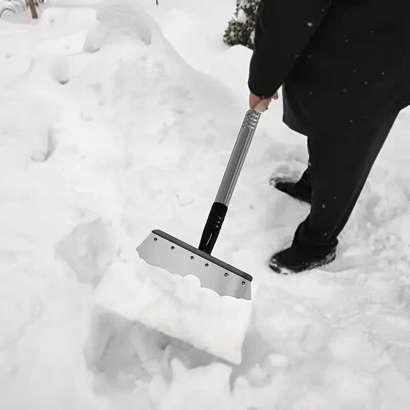 Snow and ice cleaning shovel with silver blade and wood handle, scraping ice and snow