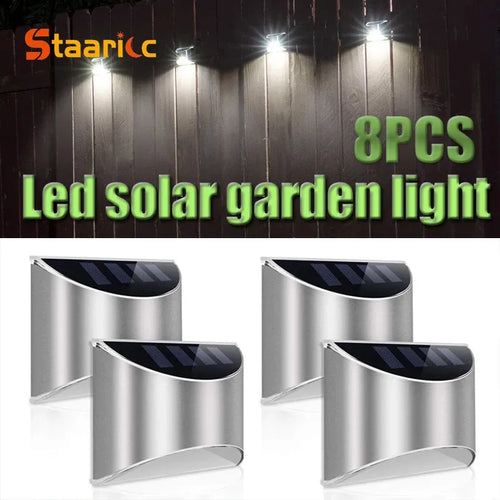 Four curved stainless steel solar wall lights with integrated top solar panels for outdoor illumination.