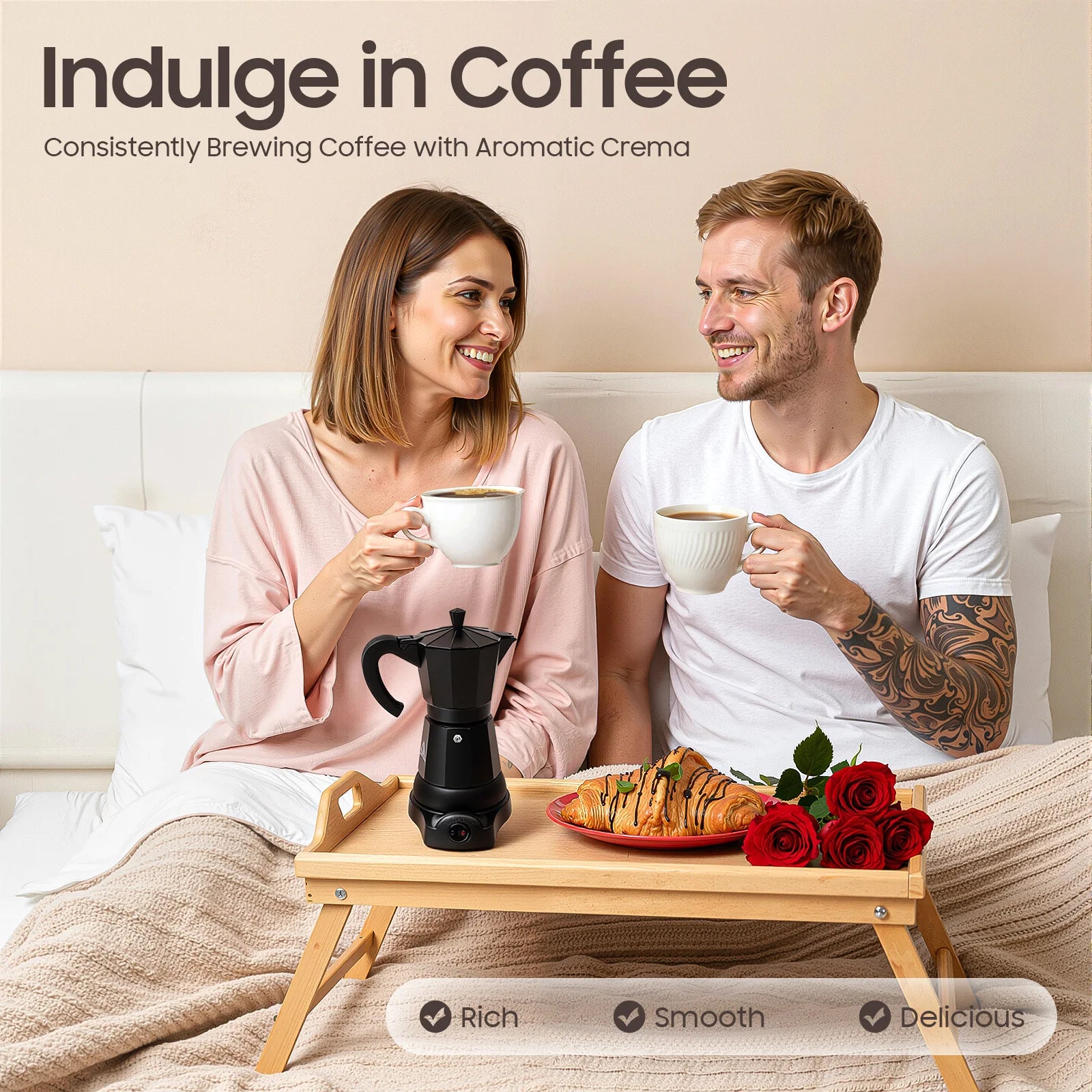 Couple in bed with a black electric moka pot coffee maker on a wooden breakfast tray with croissants and red roses.