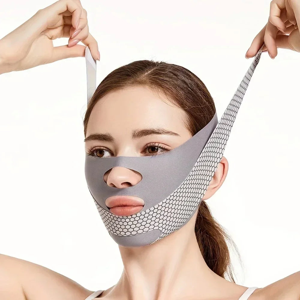 A woman wears a grey, breathable V-line face slimming bandage with a honeycomb pattern and cutouts for nose and mouth.
