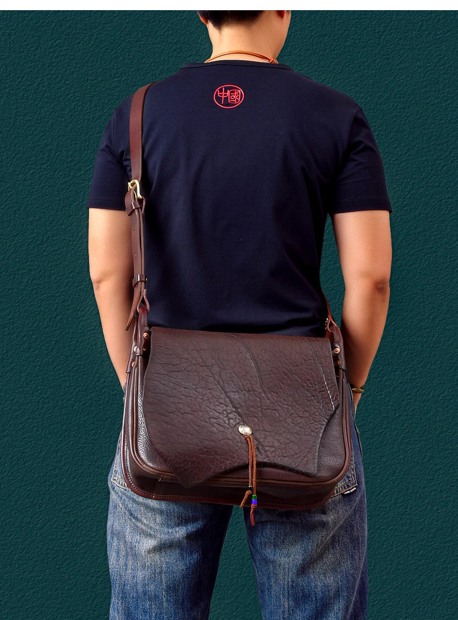 Vintage dark brown handmade cowhide leather messenger bag with flap closure and adjustable shoulder strap.