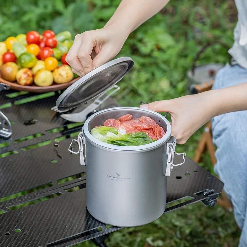 Titanium rice cooker pot with open lid, cooking greens and meat inside
