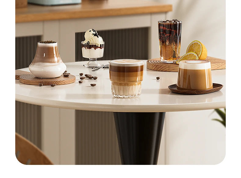 Set of clear borosilicate glass coffee cups and dessert glasses for lattes and iced coffee on a modern white table.