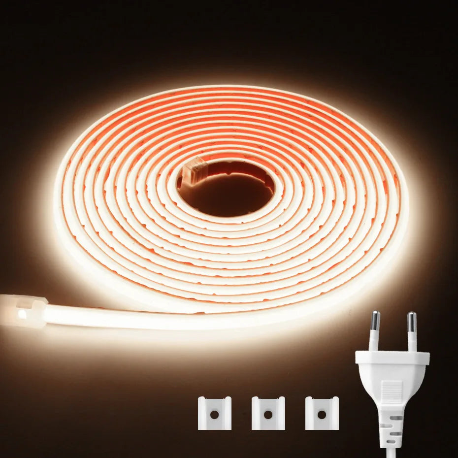 Warm white COB LED strip light coiled, with EU/AU plug and three adapter pins.