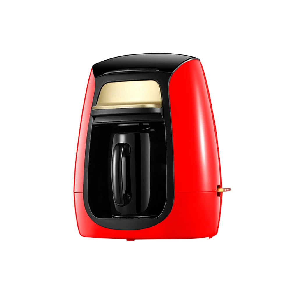 Red single-serve coffee maker with gold accents and black mug on a white background.